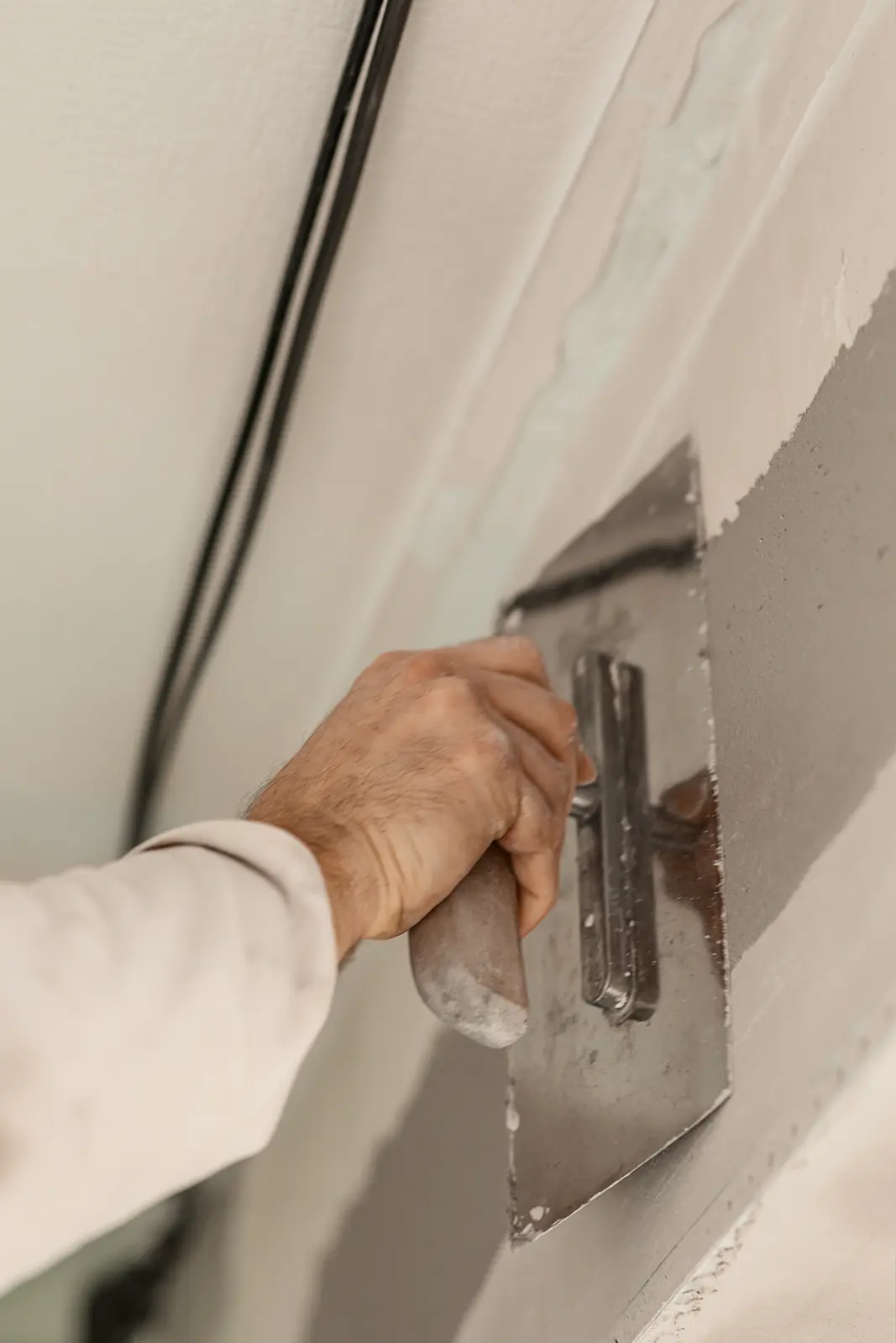 Craftsperson smoothing plaster onto an interior wall